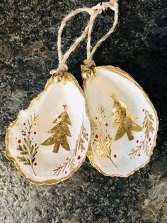 two white and gold christmas ornaments on a granite surface