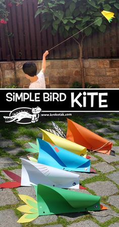 a kid flying a kite made out of paper on top of some bricks and grass