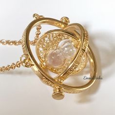 New Gold Plated Hourglass Rotating Time Turner Necklace Would Make A Fantastic Gift For A Harry Potter Fan! Necklace Is Like Hermione’s Time Turner Necklace Features~ 3 Rotating Circles Smallest With Actual Sand Hourglass Sand Is Gorgeous Iridescent Pink Tone (Note: Sand Does Go From One Chamber To The Other However Not In A ‘Timed’ Fashion. It Doesn’t Actually Keep Track Of Time, Rather, For Appearance) Cut Out Star Background Text Around The Edges Of The Pendant That Reads, “I Mark The Hours, Hermione Time Turner Necklace, Time Turner Necklace, Sand Hourglass, Kawaii Necklace, Time Turner, Background Text, Fan Necklace, Star Background, The Hours