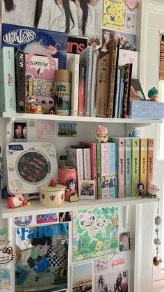 a book shelf filled with lots of books next to a wall covered in pictures and photos