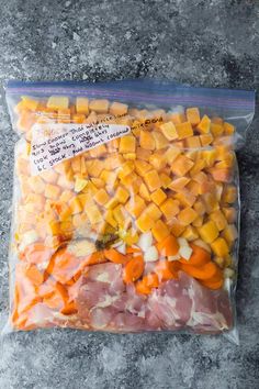 a bag filled with meat and vegetables sitting on top of a stone counter next to a knife