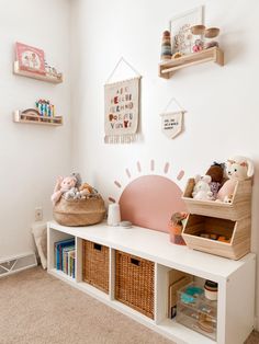 a white room with shelves and toys on the wall, including stuffed animals in baskets