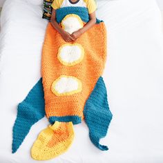 a little boy laying on top of a bed covered in a crocheted fish blanket