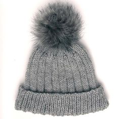 a gray knitted hat with a fur pom - pom on the top