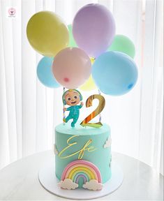 a birthday cake with balloons and a monkey on top