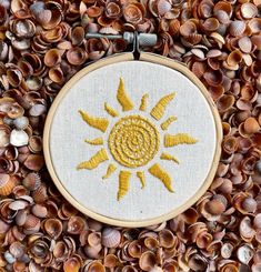 a cross stitch sun surrounded by seashells