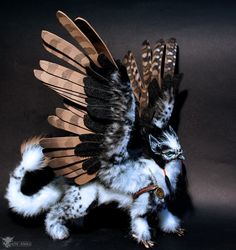 an owl with feathers on it's back and wings spread out