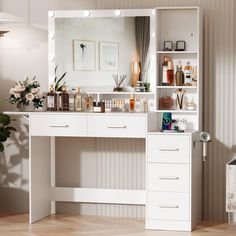 a white vanity with lighted lights and flowers on the top shelf in front of it