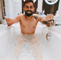 a man is sitting in the bathtub with his arms spread out and eyes closed