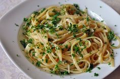 a white bowl filled with pasta and parsley