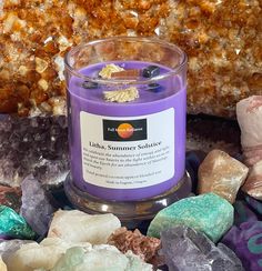 a purple candle surrounded by rocks and crystals