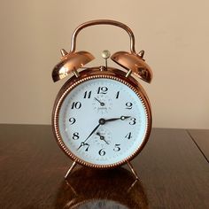 an alarm clock sitting on top of a wooden table