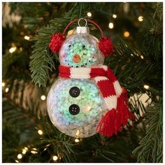 a snowman ornament hanging from a christmas tree