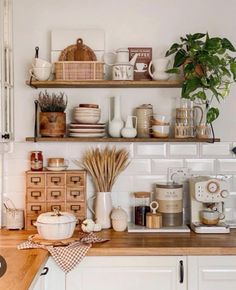 a kitchen with white cabinets and shelves filled with dishes