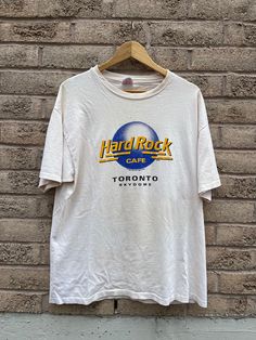 Vintage Hard Rock Cafe SkyDome Toronto 1989 T-shirt  Hanes Heavyweight tag Size XL 22.5 pit to pit  29 length Good condition   Be aware that these are used clothes and may have some blemishes, I have tried to disclose them as best as I can, please look at the pictures carefully! Reminder I am not responsible for packages lost in mail carrier as that is out of my control!  All Sales Are Final  Thanks for looking on 705Vintage Etsy page! For more follow our Instagram page- @705Vintage Hard Rock Cafe Sweater, Mail Carrier, Apa Aja, Rock Cafe, Hard Rock Cafe, Hard Rock, Toronto, That Look, No Response