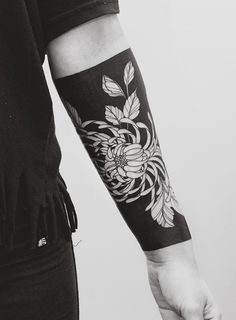 a person with a flower tattoo on their arm and hand is holding something in the other hand