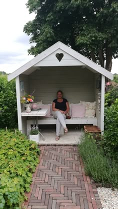 a woman sitting on top of a white bench