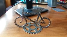 an old bicycle gear sits on a wooden table