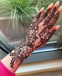 a woman's hand with henna tattoos on it