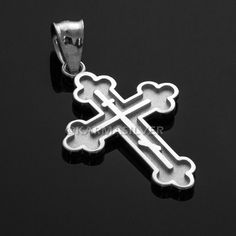 a silver cross pendant on a black background