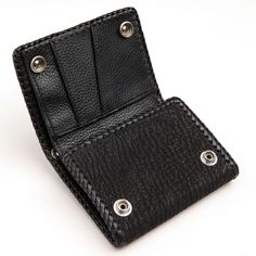 Genuine Black Stingray Gothic Cross Biker Chain Wallet New   Genuine black stingray (applique), shark skin leather (exterior), and cowhide (interior);  Internal layout: 9 Credit Card Slots, 1 Bills Compartment and 1 Zip Compartment;  Flame 925 Sterling Silver Snap and Grommet for Wallet Chain;  Wallet measures: 4 3/4" x 3 5/8";  Hand-made piece.   Summon the untamed seas with this work of leathercraft. In our Genuine Black Stingray Gothic Cross Biker Chain Wallet, two distinct dark leathers emer Rectangular Leather Wallet With Pebbled Texture, Black Textured Leather Rectangular Wallet, Black Textured Leather Bifold Wallet, Shark Skin, Biker Chain, Gothic Cross, Gothic Crosses, Chain Wallet, The Untamed