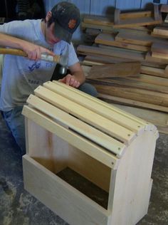 a man holding a baseball bat next to a pile of wooden planks in a warehouse