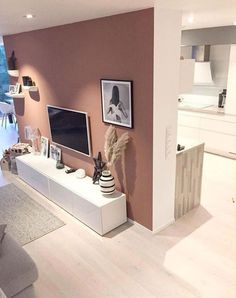 a living room filled with furniture and a flat screen tv on top of a white entertainment center