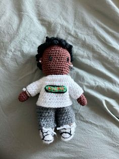 a crocheted doll laying on top of a bed