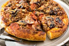 a close up of a pizza on a plate with a knife and fork next to it