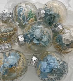 six glass ornaments with blue and white flowers in them