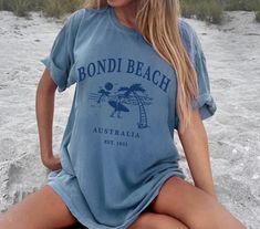 Bondi Beach Tee Shirt, Unisex Sydney Australia Tshirt Gift The Comfort Colors C1717 100% Ring Spun Cotton T-Shirt is very appropriately-named. All colors are inspired by nature and have a perfect lived-in, weathered look. Shirts are sent through a unique dyeing process that makes them incredibly soft and long-lasting. Each piece is soft-washed 50 times before making its way to you! Stitched at the collar, armhole, sleeves and bottom hem for ultimate durability, you will notice the density and quality of this shirt, but won't mind living in it. COMFORT COLORS 1717 ADULT TEE 6.1 Oz/SqYd 100% Ring Spun Cotton Soft-washed garment-dyed fabric Double-needle collar Twill taped neck and shoulders Twill label Relaxed fit Double needle armhole, sleeve and bottom hems Tubular body GILDANSWEATSHIRT .: Nike Winter Jackets, Perfect Live, Beach Tee, Bondi Beach, Beach T Shirts, Surfer Girl, Limassol, Dyeing Process, Beach Shirts