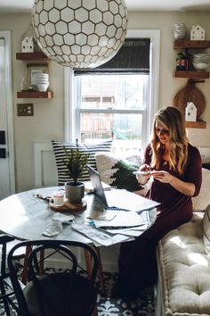 a woman sitting at a table with a laptop