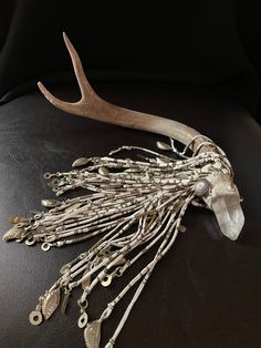 a deer's antler is adorned with beads and chains