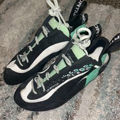 a pair of black and white sneakers with green accents on the soles are shown