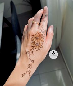 a woman's hand with a flower tattoo on it