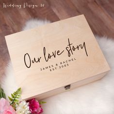 a wooden box with the words our love story written on it and flowers in front