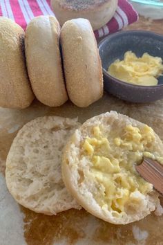 there are some breads and butter on the table next to each other with a spoon in it