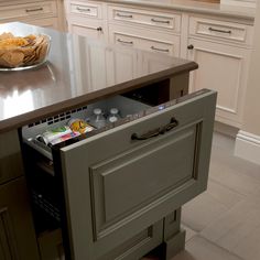 an open drawer in the middle of a kitchen island