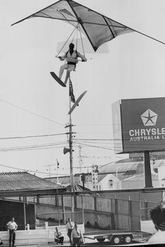 a man flying through the air while riding a kite