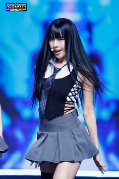 a woman with long black hair wearing a skirt