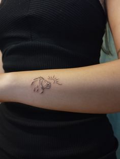 a woman's arm with a small tattoo on the left side of her arm