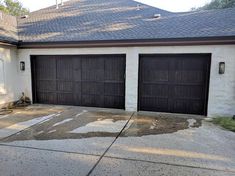 two brown garage doors in front of a white house