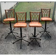 four stools with barstools in front of a fence