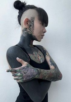 a woman with tattoos on her face and arms