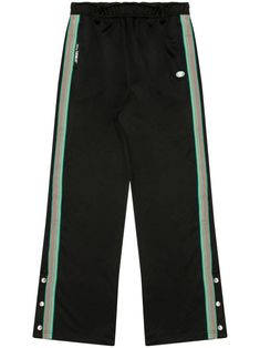 black/green stretch-jersey side stripe detailing appliqué logo logo patch to the rear elasticated waistband belt loops side press-stud fastening at the ankles straight leg Green Bottoms With Side Stripes For Streetwear, Green Sweatpants With Side Stripes For Streetwear, Sporty Green Pants With Elastic Side Panels, Green Side Stripe Pants For Streetwear, Green Pants With Side Stripes For Streetwear, Green Streetwear Pants With Side Stripes, Green Athleisure Bottoms With Side Stripes, Sporty Black Sweatpants With Contrast Stripes, Sporty Joggers With Logo Waistband For Streetwear