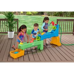 three children playing with toys on a deck