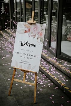 a welcome sign with pink flowers on it