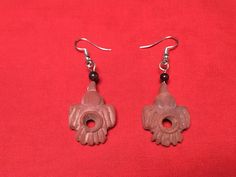 pair of earrings with flower design on red background