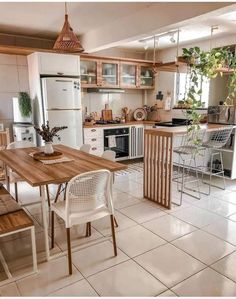 a kitchen filled with lots of white appliances and wooden table next to a stove top oven