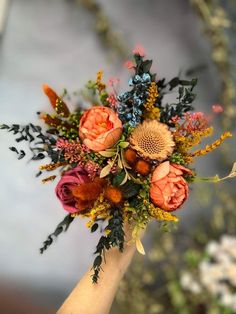 a bouquet of flowers is being held by someone's hand